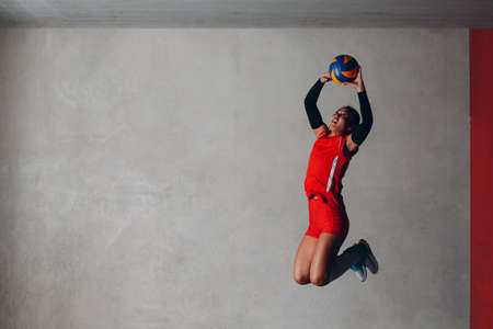 Young woman smiling volleyball player with ballの写真素材