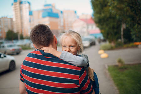 Rear view of father walking back to school with his little daughter.の写真素材