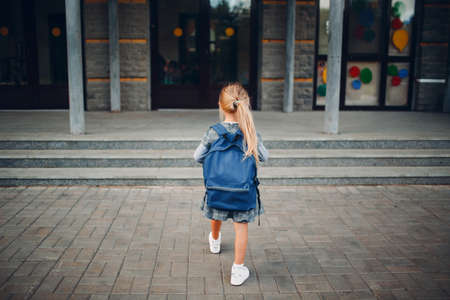 Cute little girl with backpack walking back to schoolの写真素材