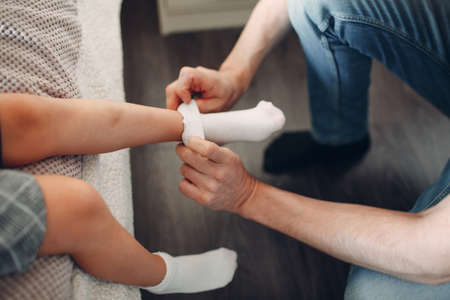 Father helping daughter dressing uniform and socks preparation back to schoolの写真素材