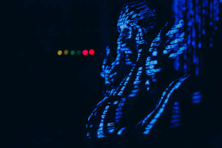 Young man with blue letters on his face in the dark.
