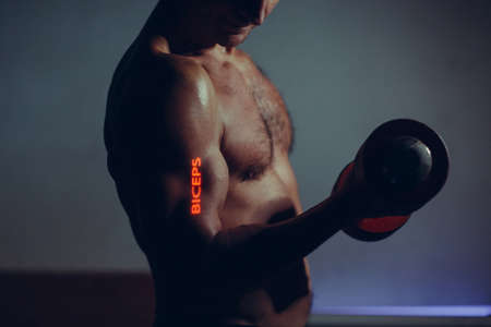 Young Adult Man Working Out Biceps with Dumbbell with word on his handの写真素材