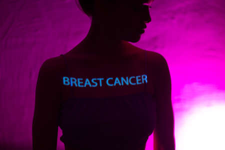 Young adult woman with words Breast Cancer on her chestの写真素材