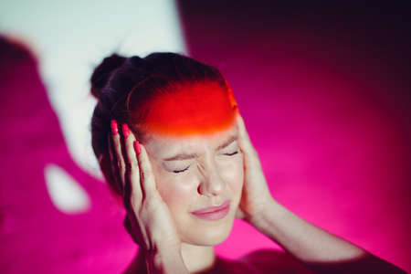 Young woman with headache and red color foreheadの写真素材