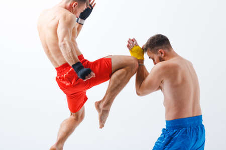 Two men boxers fighting muay thai kick knee in jump boxing white background. Motion blur.の写真素材