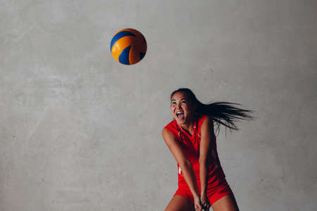 Young woman smiling volleyball player with ballの写真素材