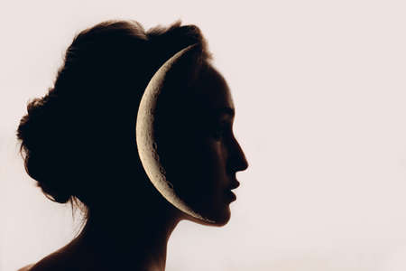 Beautiful woman profile silhouette portrait with moon in her head. Feminism concept.の写真素材