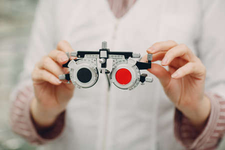Optometrist red blue diopter in optician ophthalmologist handsの写真素材