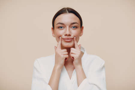 Young woman doing face building facial gymnastics self massage and rejuvenating exercises