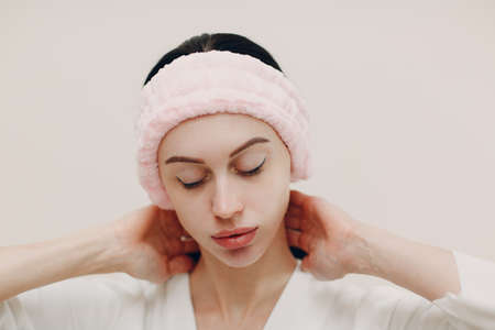 A beautiful young woman portrait in pink cosmetic bandage towel on her head