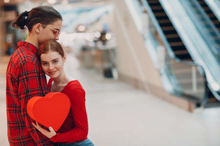 beautiful happy young couple with shopping bags in shopping mall escalatorの写真素材