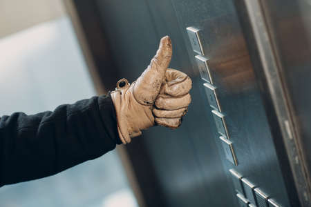 Close up of thumbs up pressing the button elevator during  pandemic
