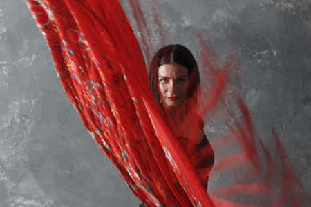 Young adult spanish woman dancing flamenco on gray vintage background with motion blurの写真素材