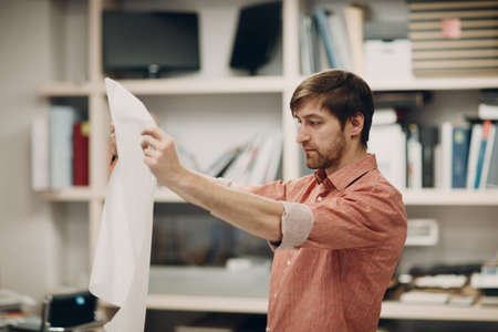 Architect with blueprints and layout design project at officeの写真素材