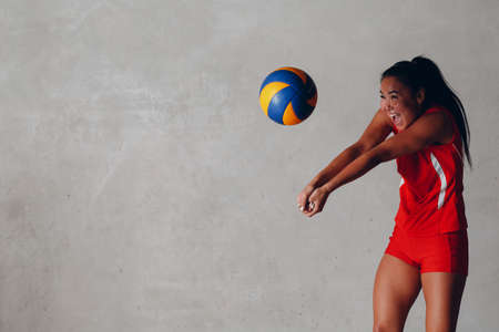 Young woman smiling volleyball player with ballの写真素材