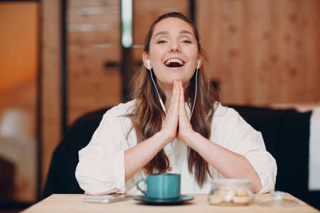 Screen app view of smiling young female sit at table with laptop and talking on video call with...