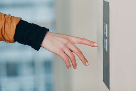 Close up of forefinger pressing the button elevator during pandemic  quarantine conceptの写真素材