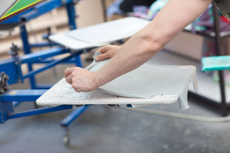 Prepare for printing and apply cloth Serigraphy silk screen print process at clothes factory