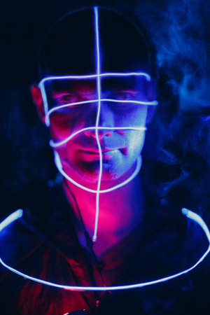 Portrait of man with neon glow lines on his face. Concept cyberpunkの写真素材