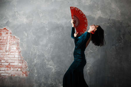 Woman dancer dancing flamenco on gray vintage studio backgroundの写真素材