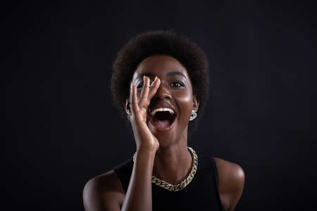 Portrait of black african american woman holding palm hand near wide open mouth yelling screaming shoutの写真素材