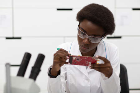 Scientist african american woman working in laboratory with electronic board. Research and development by color black woman.の写真素材