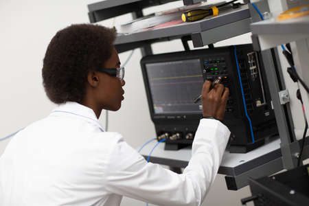 Scientist african american woman working in laboratory with oscillograph. Research and development...