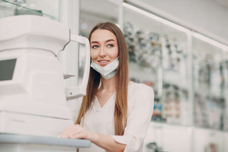A woman doctor and patient doing opthalmology refractometer check vision test.の写真素材