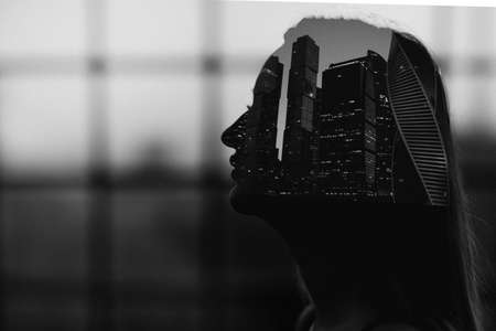 Double exposure black and white portrait of woman silhouette inside city skyscrapers urban building with film grainの写真素材