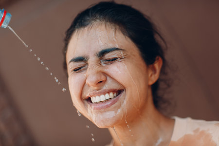 Stressed woman suffering of heatstroke and refreshing pouring with cold water outside. Weather abnormal heat conceptの写真素材