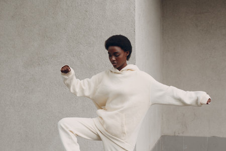 Young african american woman stretching and warming up exercises outdoor. Fitness and outside sport...