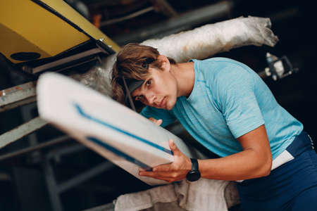 Sportsman single scull man rower prepare to competition boat regatta.