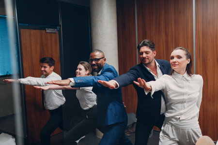 Businessman and businesswoman team doing warm-up and yoga exercises before office meeting. Business healthy successful people group man and woman after conference discussion with boss.の写真素材