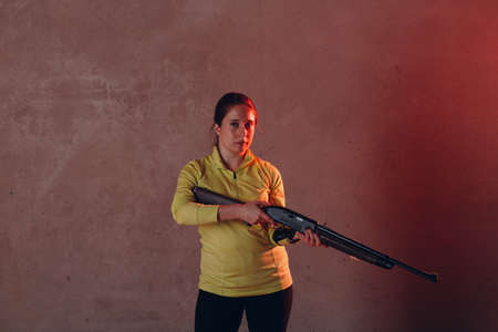 Young adult woman with rifle. Self defence concept.の写真素材