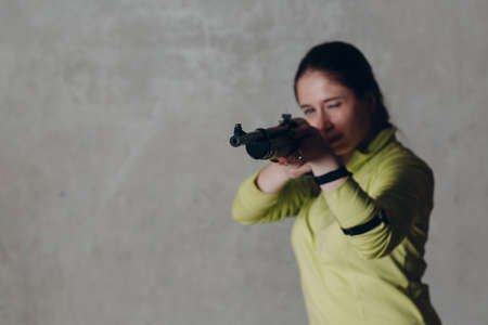 Young adult woman with rifle. Self defence concept.の写真素材