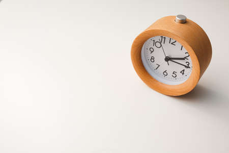 Wooden alarm clock on white table background.の写真素材