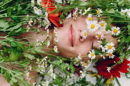 Young man model with flowers. Beauty boy portraitの写真素材