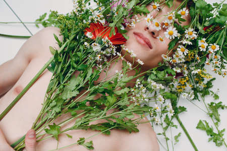 Young man model with flowers. Beauty boy portraitの写真素材