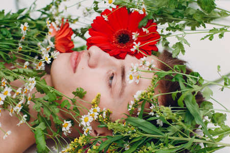 Young man model with flowers. Beauty boy portraitの写真素材