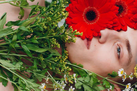 Young man model with flowers. Beauty boy portraitの写真素材