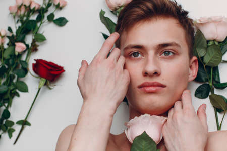 Young man model with flowers. Beauty boy portraitの写真素材