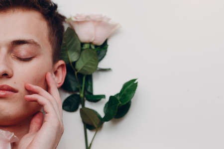 Young man model with flowers. Beauty boy portraitの写真素材