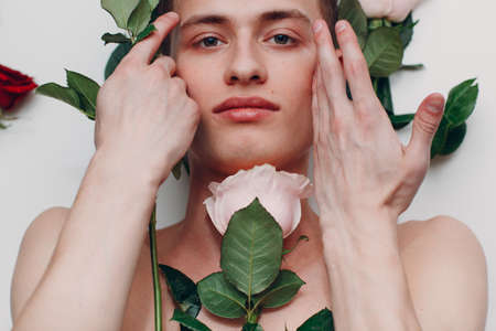 Young man model with flowers. Beauty boy portraitの写真素材