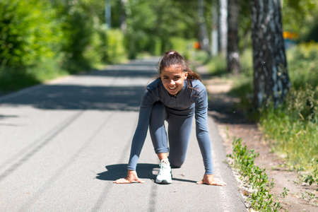 Athletic woman on track starting to run. Jogging pretty girl.の写真素材