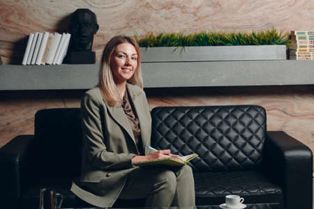 Business woman young adult coach sitting with notebook book at officeの写真素材