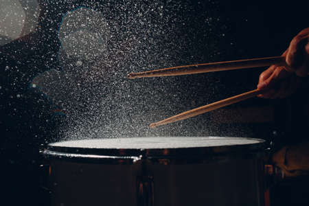 Close up drum sticks drumming hit beat rhythm on drum surface with splash water dropsの写真素材