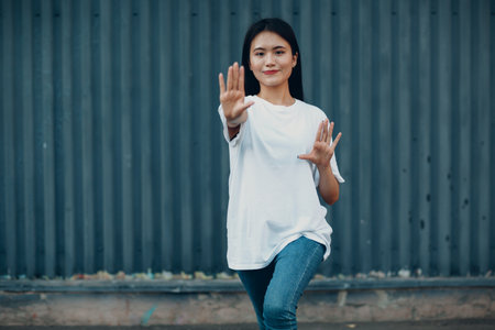 Asian young woman doing qigong exercise summer outdoor wallの写真素材