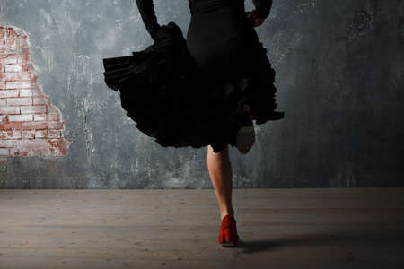 Young adult spanish woman dancing flamenco on gray vintage studio backgroundの写真素材