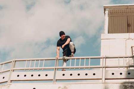 Young sporty guy doing parkour at the city streetの写真素材