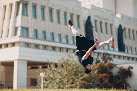 Young sporty guy doing parkour at the city streetの写真素材